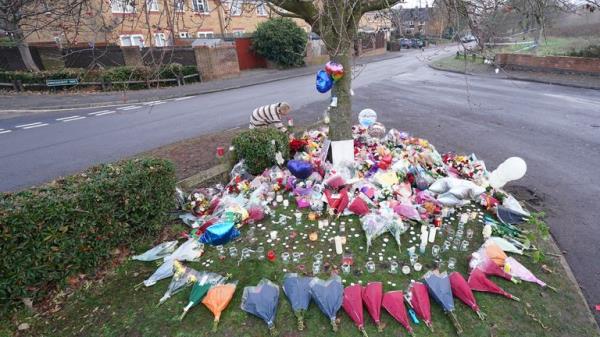 A woman lays flowers among the tributes near to Babbs Mill Park in Kingshurst, Solihull, after the deaths of three boys aged eight, 10 and 11 who fell through ice into a lake in the West Midlands. Picture date: Tuesday December 13, 2023.
