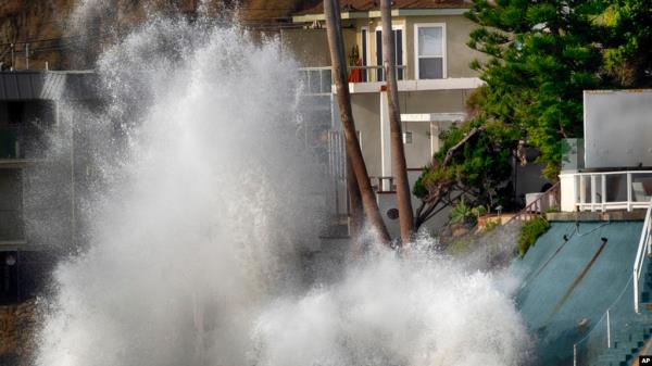 Waves smash against a sea wall next to homes along the California coast in Malibu Beach, Calif., on Dec. 29, 2023.