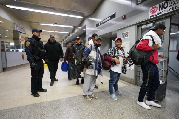 Migrants guided to Manhattan trains.